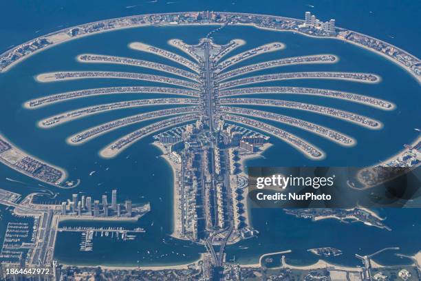 Aerial view from an airplane window of Palm Jumeirah artificial islands over the city view, on the Persian Gulf in Jumeirah, Dubai, United Arab...