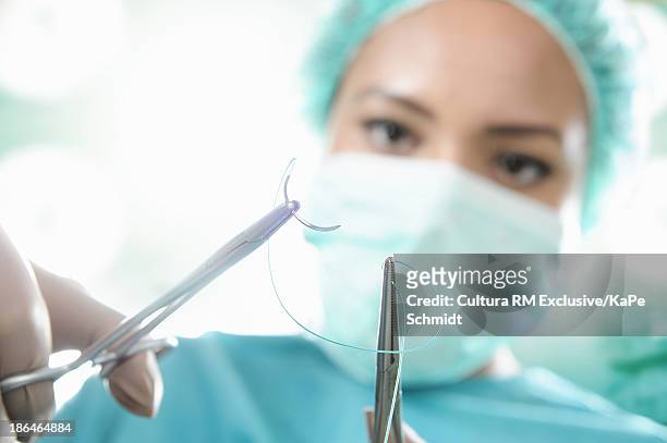 surgeon preparing surgical instrument - suture - fotografias e filmes do acervo