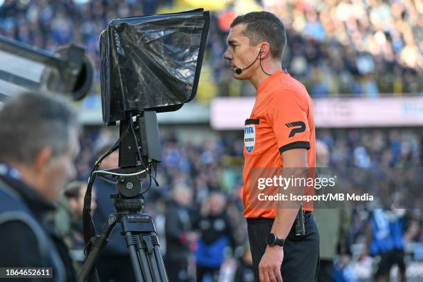 Referee Jonathan Lardot checks the VAR screen during the Jupiler Pro League season 2023 - 2024 match day 18 between Club Brugge KV and AA Gent on...