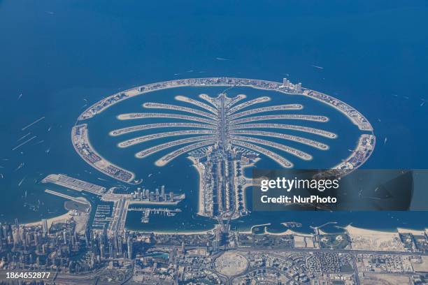 Aerial view from an airplane window of Palm Jumeirah artificial islands over the city view, on the Persian Gulf in Jumeirah, Dubai, United Arab...