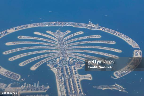 Aerial view from an airplane window of Palm Jumeirah artificial islands over the city view, on the Persian Gulf in Jumeirah, Dubai, United Arab...