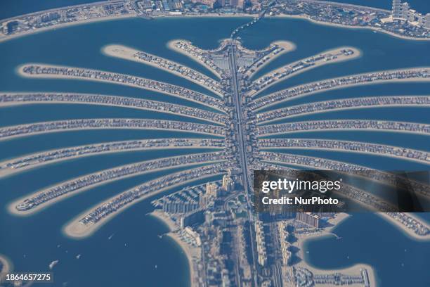 Aerial view from an airplane window of Palm Jumeirah artificial islands over the city view, on the Persian Gulf in Jumeirah, Dubai, United Arab...