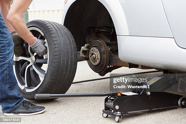 germany, bavaria, kaufbeuren, mature man changing car tire - car jack stock pictures, royalty-free photos & images