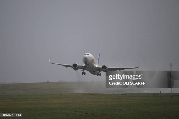 Passnger jet takes off in strong winds from Leeds Bradford airport in northern England on December 21 as Storm Pia brings high winds to many parts of...