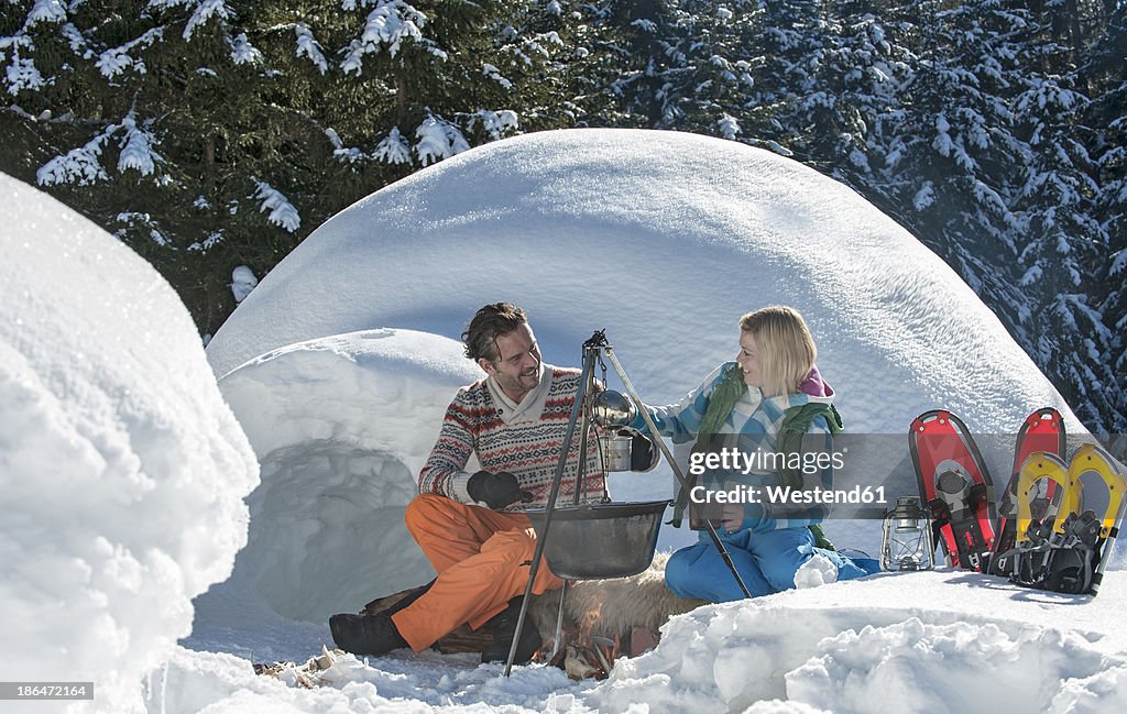 Austria, Salzburg, Couple preparing tea near igloo