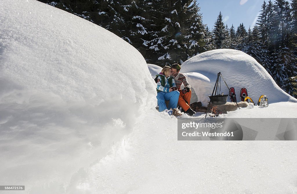 Austria, Salzburg, Couple preparing tea near igloo