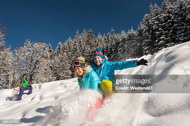 austria, salzburg, young man and women with sledge in snow at altenmarkt zauchensee - salzburger land stock pictures, royalty-free photos & images