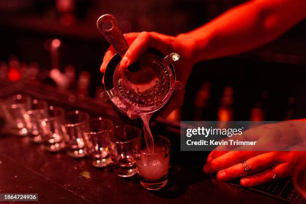 pouring shots at a dark bar - comazuipen stockfoto's en -beelden