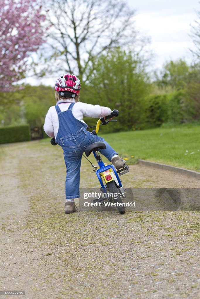 Girl with helmet driving bicycle