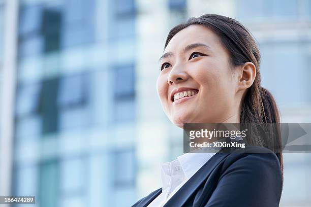 low angle of a young businesswoman smiling - low motivation stock pictures, royalty-free photos & images