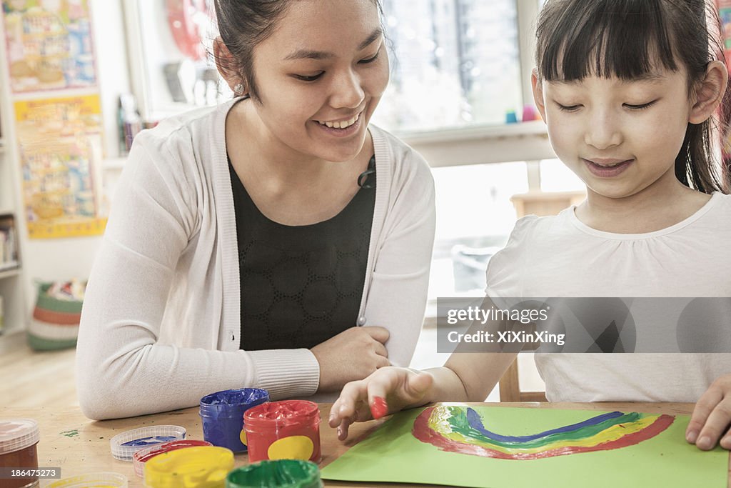 Teacher and student finger painting in art class