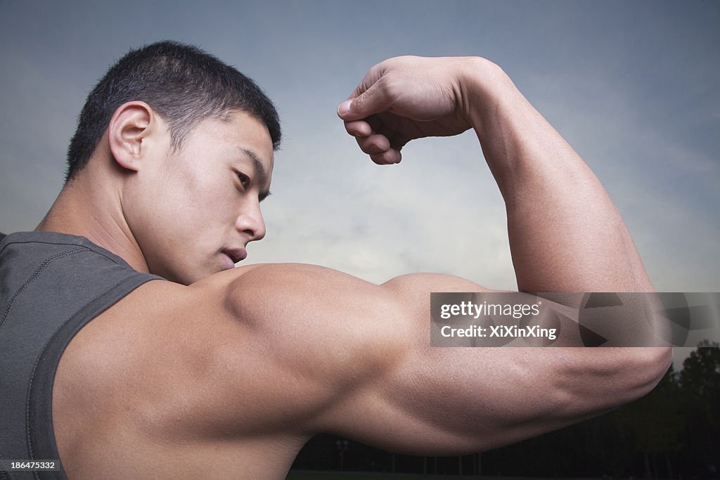 Young Man showing off his bicep muscles