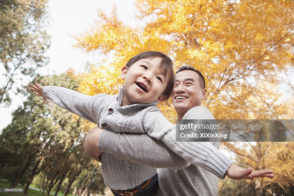 Father and Son Playing at Park in Autumn