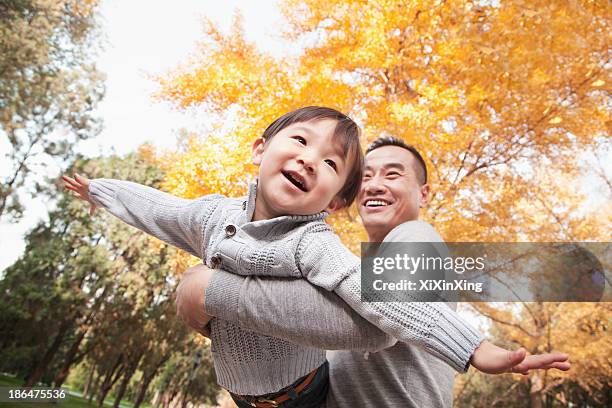 father and son playing at park in autumn - short trees bildbanksfoton och bilder