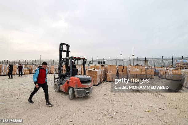 Boxes containing humanitarian aid are unloaded at the Karm Abu Salem crossing in Rafah in the southern Gaza Strip, on December 21 amid the ongoing...