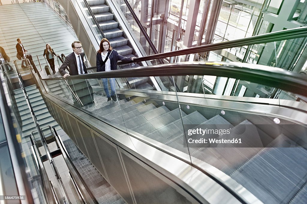 Germany, Cologne, People moving up escalator at airport