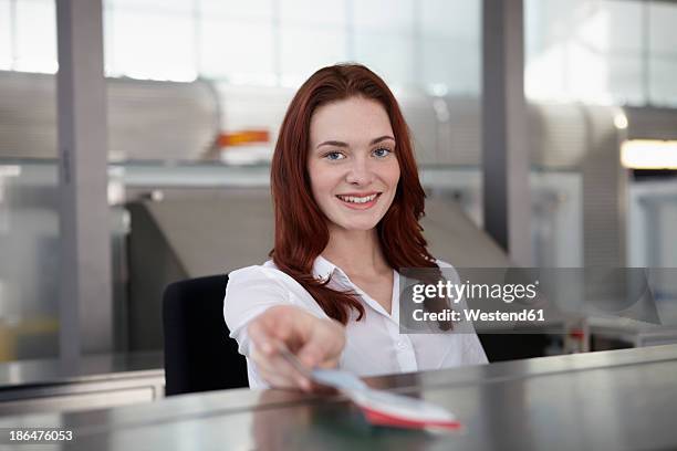 germany, cologne, young woman giving ticket, smiling - taquilla lugar de comercio fotografías e imágenes de stock