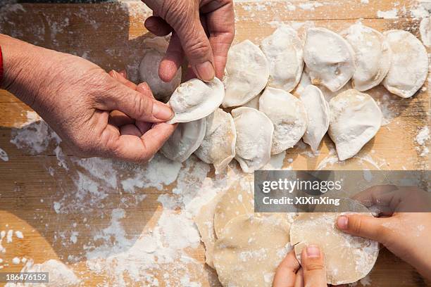 senior woman and girl making dumplings, hands only - bolinho de massa imagens e fotografias de stock