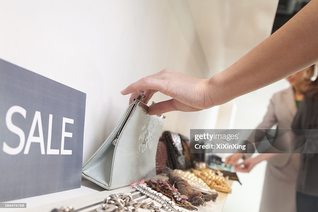 Young woman shopping for accessories at store, close-up