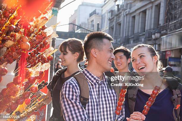 young people buying candied haw. - beijing tourist stock pictures, royalty-free photos & images