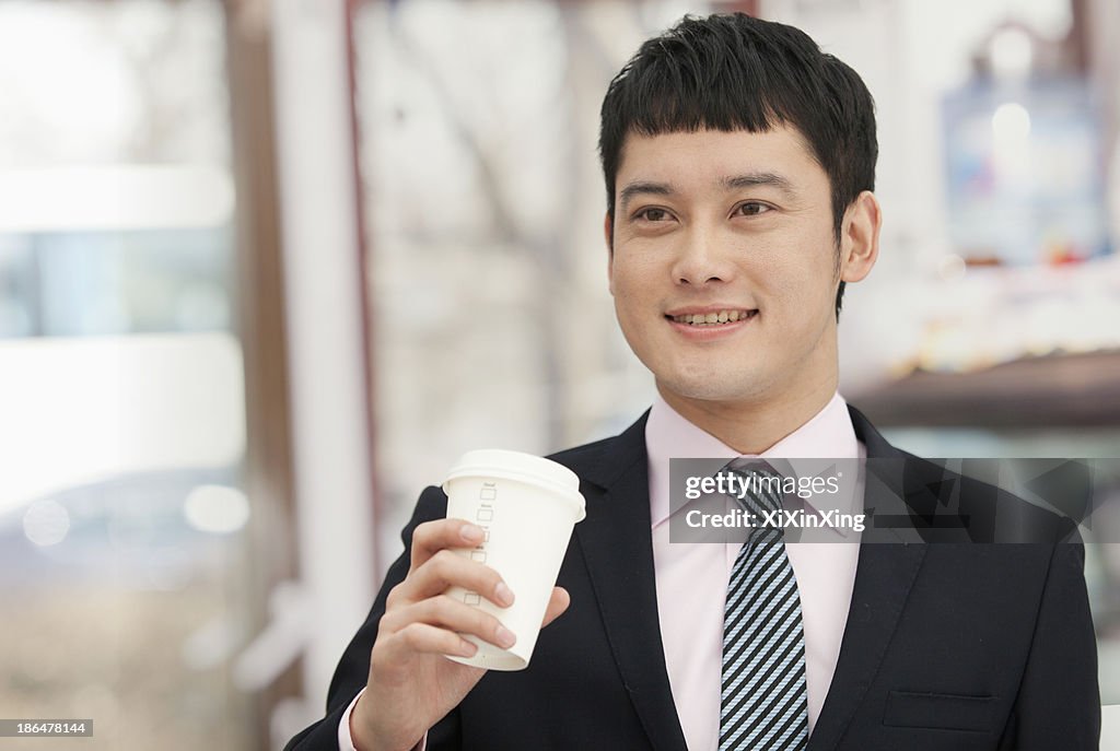 Smiling business man holding coffee cup