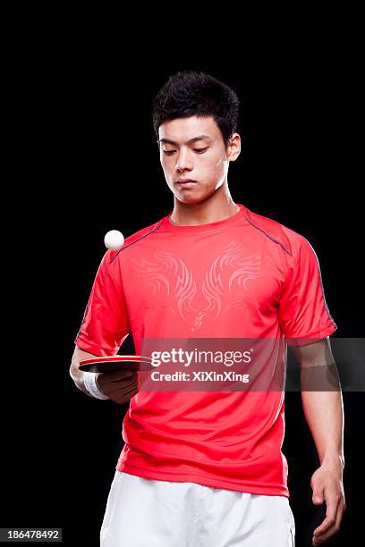 man playing ping pong, black background - xi ping stock pictures, royalty-free photos & images