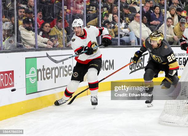 Travis Hamonic of the Ottawa Senators clears the puck ahead of William Carrier of the Vegas Golden Knights in the second period of their game at...