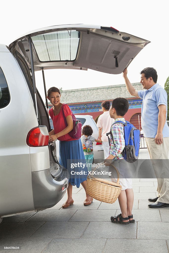 Family taking stuff out from the car, preparing for picnic