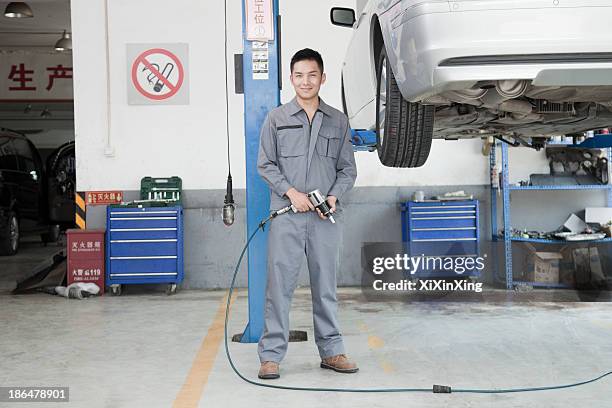 mechanic using power tool - mechanic uniform stock pictures, royalty-free photos & images