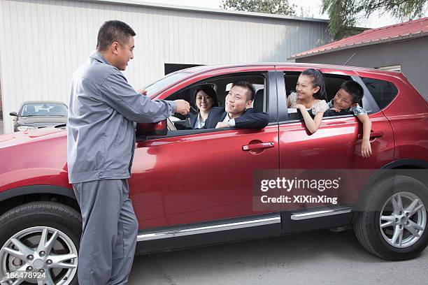 mechanic giving car keys to family - asian couple garage car stock pictures, royalty-free photos & images