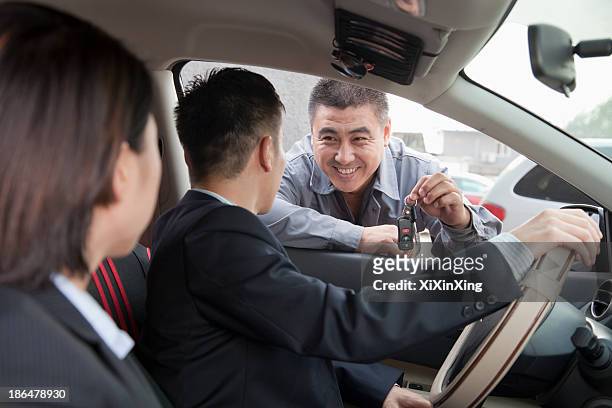 mechanic giving car keys to couple - asian couple garage car stock pictures, royalty-free photos & images