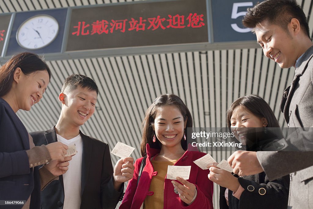 Group of people looking at tickets at the railway station