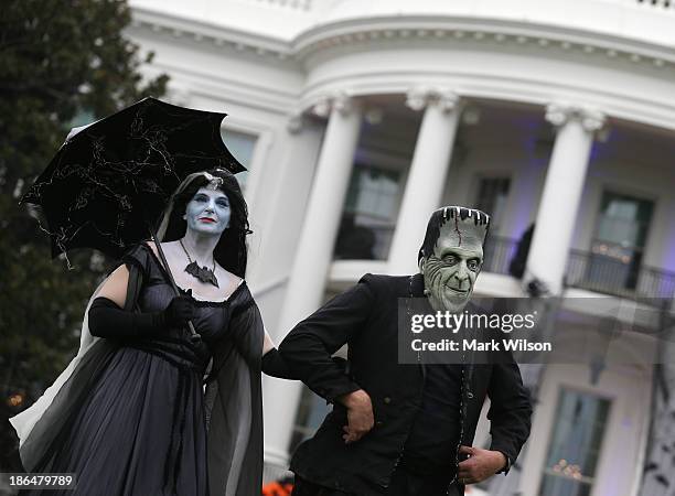 People dressed as Frankenstein and Mrs. Frankenstein stand on the South Lawn of the White House October 31, 2013 in Washington, DC. Later this...