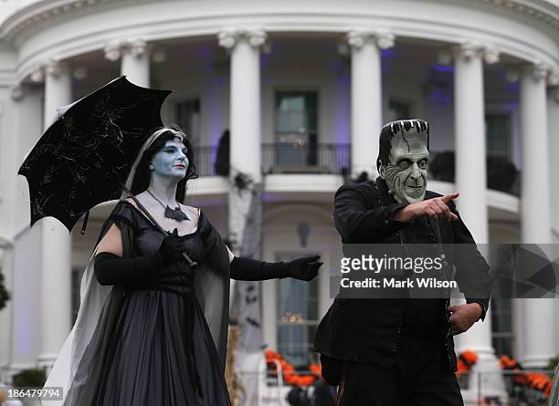 People dressed as Frankenstein and Mrs. Frankenstein stand on the South Lawn of the White House, October 31, 2013 in Washington, DC. Later this...