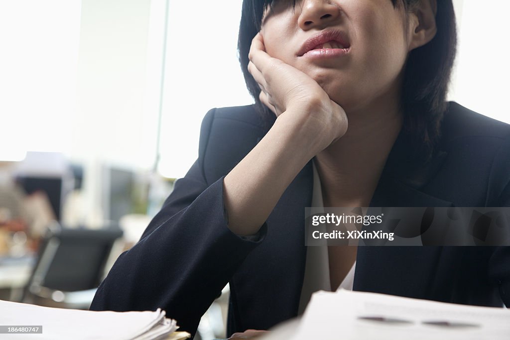Young businesswoman sitting at desk bored