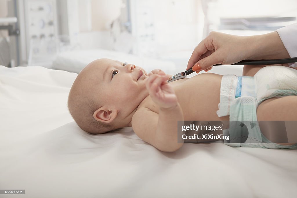 Doctors hand checking the heartbeat of a baby, close-up