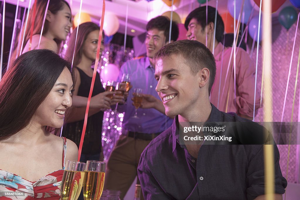 Group of friends celebrating, toasting with champagne, nightclub in Beijing