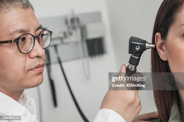 Doctor Looking In Ear Ear Exam With Otoscope Photos and Premium High Res Pictures - Getty Images