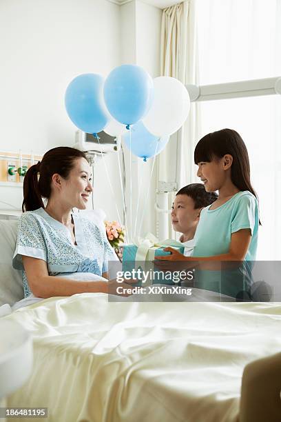 girl and boy visiting their mother in the hospital, giving present and balloons - patients brothers 個照片及圖片檔