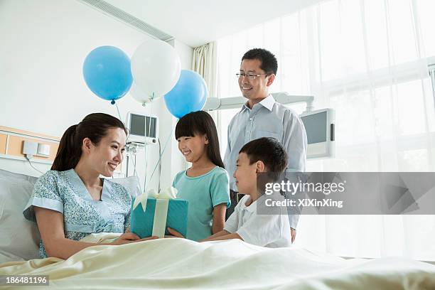 father and children visiting their mother in the hospital, giving present and balloons - patients brothers 個照片及圖片檔