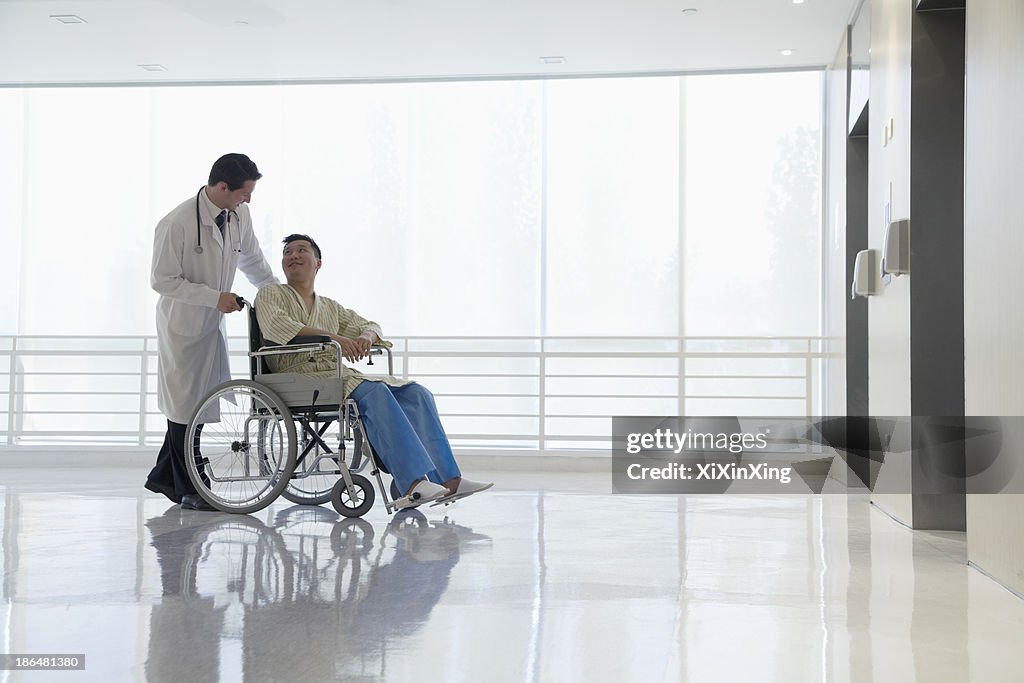 Doctor pushing and assisting patient in the hospital, Beijing, China