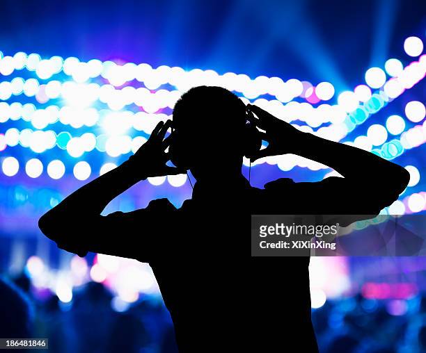 silhouette of dj wearing headphones and performing at a night club - club dj 個照片及圖片檔