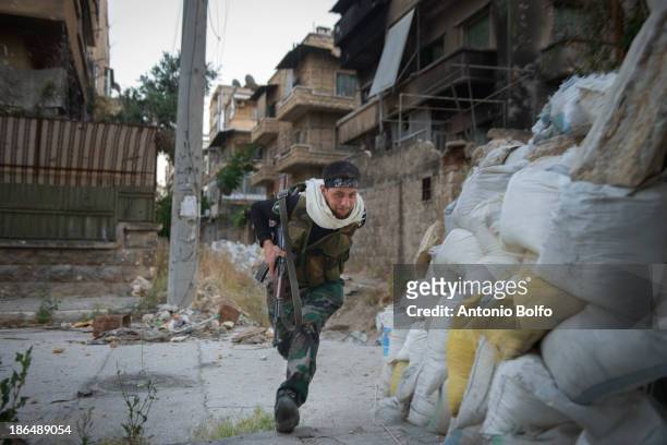 Free Syrian Army mujahideen soldier ducks through government Army sniper fire May 25, 2013 in Aleppo, Syria.