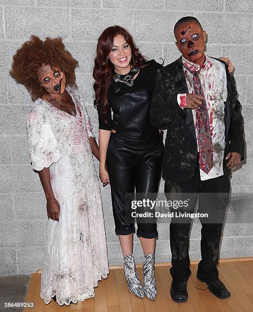 Singer Guinevere poses with two "zombies" at her live performance and meet & greet at VEVO headquarters on October 31, 2013 in Los Angeles,...