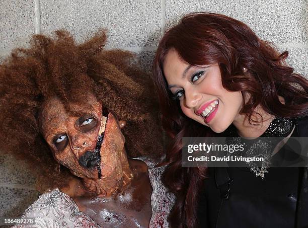 Singer Guinevere poses with a "zombie" at her live performance and meet & greet at VEVO headquarters on October 31, 2013 in Los Angeles, California.