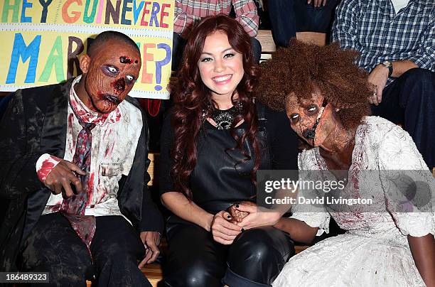 Singer Guinevere poses with two "zombies" at her live performance and meet & greet at VEVO headquarters on October 31, 2013 in Los Angeles,...