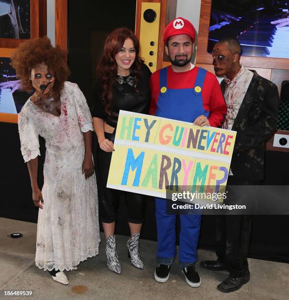 Singer Guinevere poses with two "zombies" and "Mario" at her live performance and meet & greet at VEVO headquarters on October 31, 2013 in Los...
