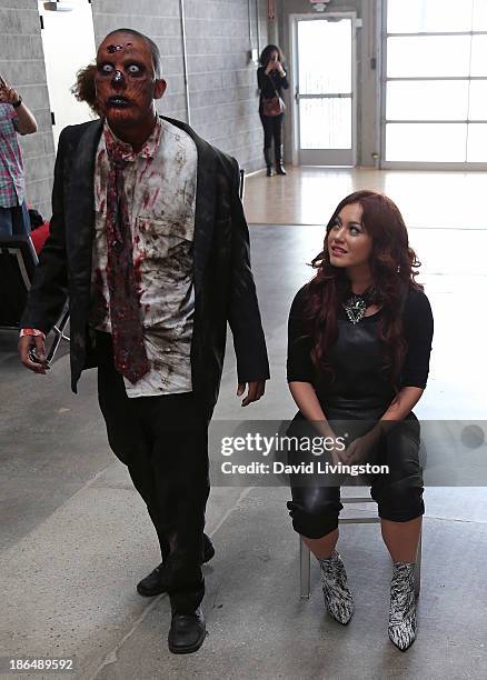 Singer Guinevere watches a "zombie" at her live performance at VEVO headquarters on October 31, 2013 in Los Angeles, California.