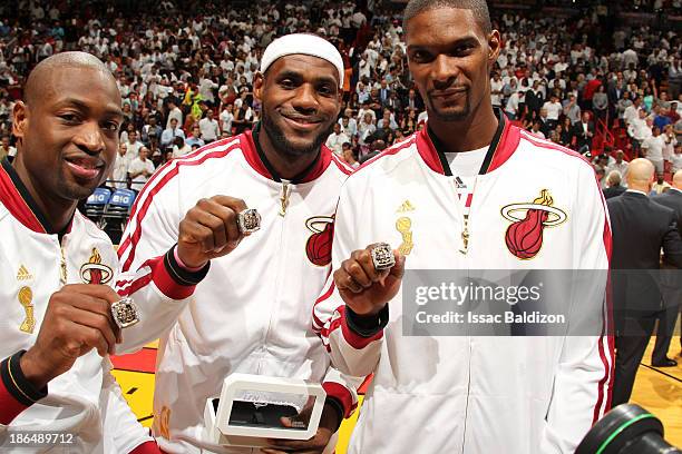 Dwyane Wade, LeBron James and Chris Bosh of the Miami Heat holds up their rings during the ceremony before the game against the Chicago Bulls on...