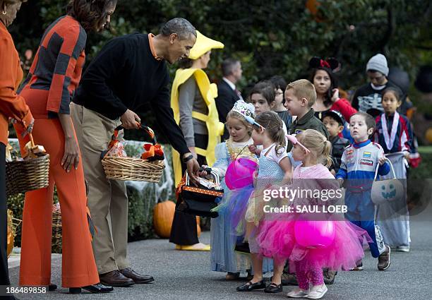 President Barack Obama and First Lady Michelle Obama hand out treats to local children and children of military families as they trick-or-treat for...